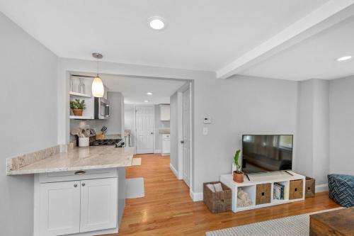 a kitchen and living room with white walls and wooden floors at Boston Condo With FREE Parking in Boston