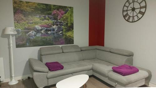 a living room with a couch and purple pillows at LILOA in La Bourboule