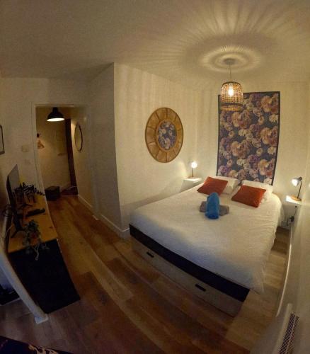 a bedroom with a bed with a blue stuffed animal on it at le Thermal 108 in Saint-Martin-d'Uriage