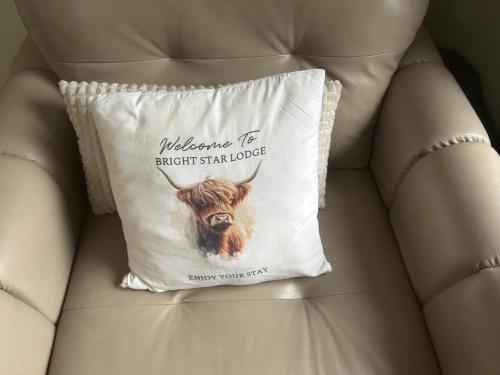 a pillow with a goat on it sitting on a couch at Bright Star Lodge in Spean Bridge