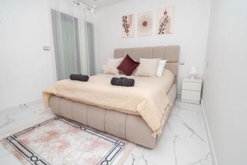 a white bedroom with a bed and a couch at Luxury Abraj YK 120m2 in Tangier