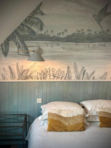a bedroom with two beds and a painting on the wall at Le Pressoir de la Gervaiserie - 300m de la plage in Réville