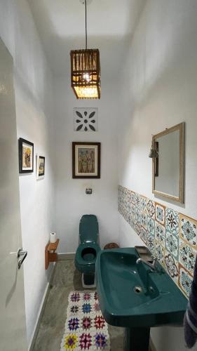 a bathroom with a green sink and a toilet at Casa Boomerang in Marau
