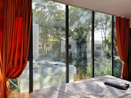 a bedroom with a bed and a large window at NeOtel Apartments in Ban Saiyuan (1)
