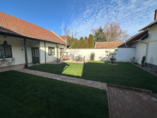 a backyard of a house with a grass yard at Casa Eloria in Békéscsaba