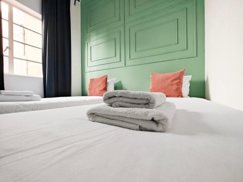 a bedroom with two beds with towels on the bed at Cosy room 7 in Tal-Pietà
