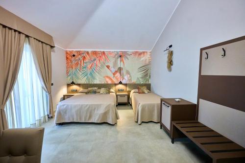 a room with two beds and a painting on the wall at Le 2 Palme Apartments in Catanzaro Lido