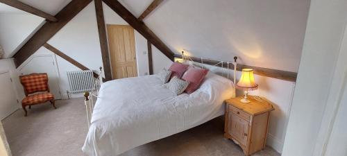 a bedroom with a bed and a lamp on a table at School House in Reeth