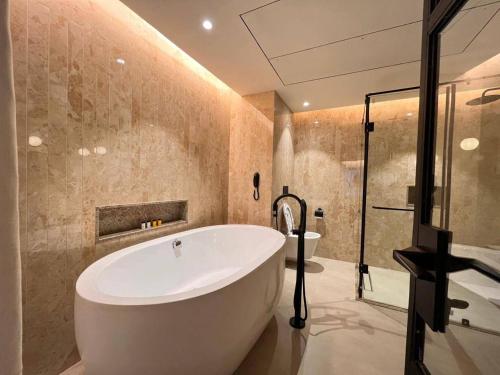a bathroom with a large tub and a shower at Hotel Poonja International in Mangalore