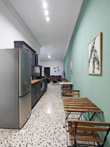 a kitchen with a refrigerator and tables and chairs at Cosy room 7 in Tal-Pietà