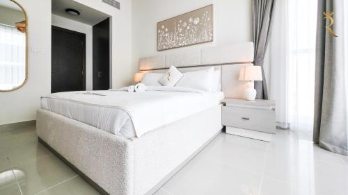 a white bedroom with a large bed and a mirror at Azure Marina 1BR - Elegant Chic Haven in Abu Dhabi