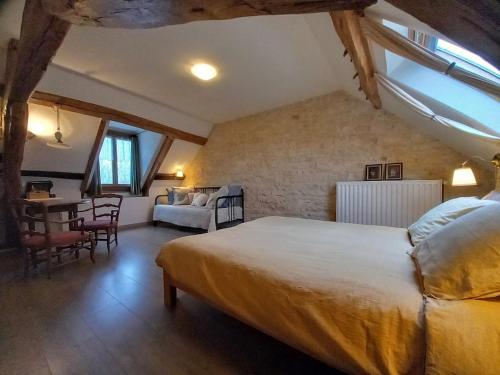 B&B Le Corbier في Herry: غرفة نوم بها سرير وطاولة وكراسي