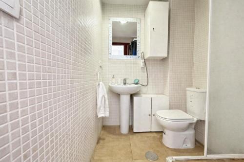 a bathroom with a toilet and a sink and a mirror at Comeback Brisa Serena in Rubite