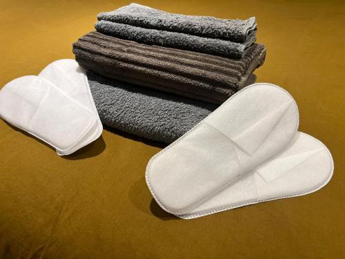 a pair of white slippers and a pile of towels at DURANCE in La Brillanne