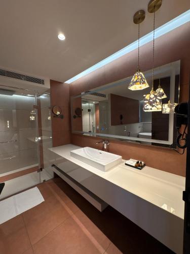 a bathroom with a sink and a large mirror at Zipp Hotel Rosalba in Bangalore