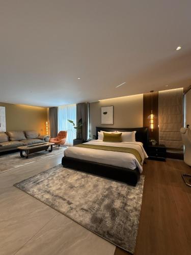 a large bedroom with a large bed and a couch at Zipp Hotel Rosalba in Bangalore