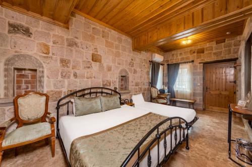 a bedroom with a bed and a stone wall at Cratus Stone Palace in Göreme
