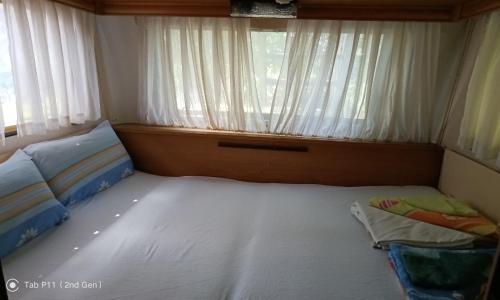 a small bedroom with a bed and a window at Граничар 3 СЪРФА - морската каюта in Granichar