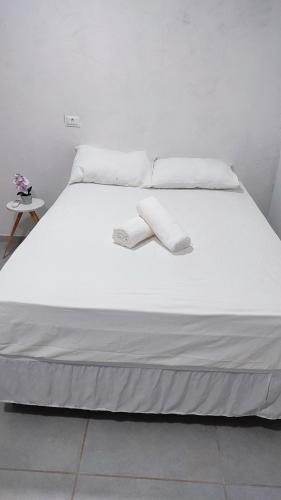 a white bed with white sheets and pillows on it at Águas de Maragogi residence in Maragogi