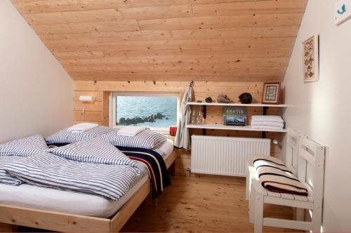 two beds in a room with a window at Tungulending Guesthouse in Tungulending