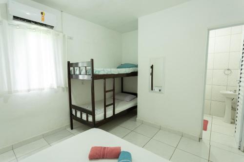 a small bathroom with a bunk bed and a shower at Pousada da Sú in Bertioga