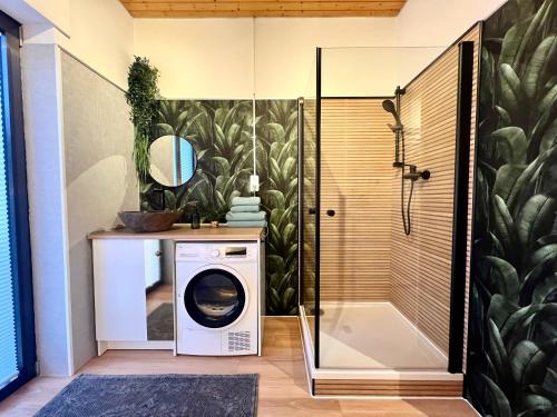 a washing machine in a bathroom with a shower at Barrierefreies Ferienhaus mit Garten bei Köln in Hürth