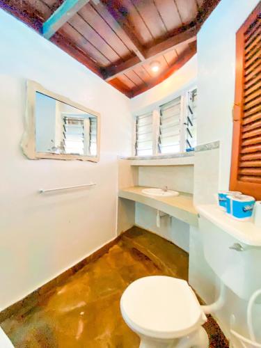a bathroom with a toilet and a sink at Palm Villa at Villa Sol in Mombasa