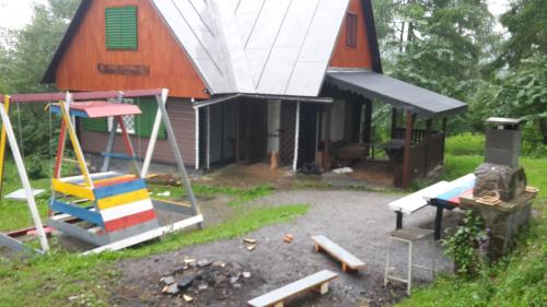 a small barn with a playground and a house at Chata Katarina in Lipany