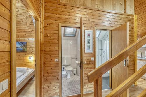 a log cabin bathroom with a shower and a toilet at Seepark-Lodge in Kirchheim