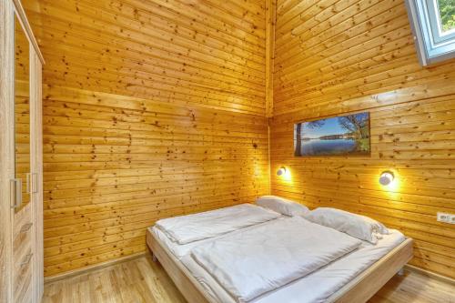 a bedroom with a bed in a wooden room at Seepark-Lodge in Kirchheim