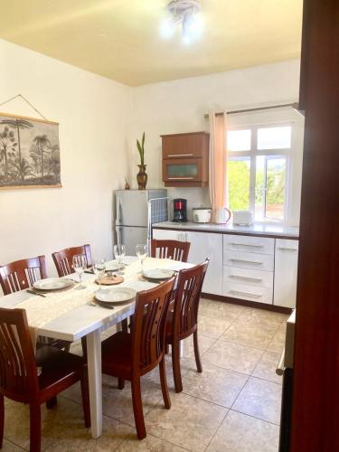 a kitchen with a table and chairs in a kitchen at Appartement first floor in Trou aux Biches