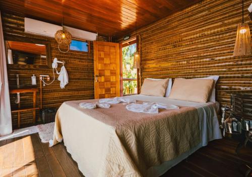 a bedroom with a bed in a wooden room at Pousada do Xerife in Caconde