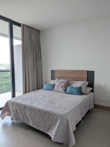 a bedroom with a large bed with a large window at Apartamento en Manzanillo con salida directa a la playa in Cartagena de Indias