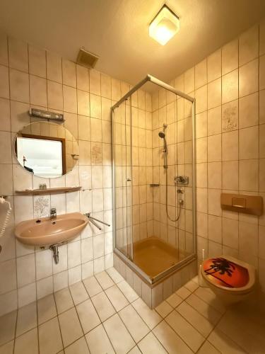 a bathroom with a shower and a sink and a toilet at Hotel Allee 25 in Stuttgart