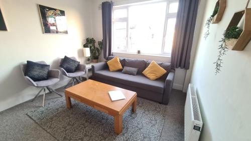 a living room with a couch and a table at 3-Bedroom Flat-FreeParking & Wifi, Sleeps7 in Bristol