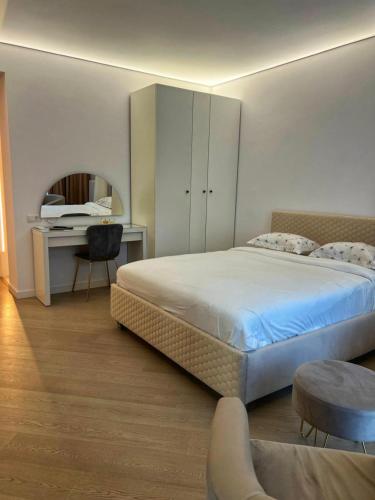 a bedroom with a large bed with a desk and a chair at Cortina - Yard & Wellness View in Voluntari