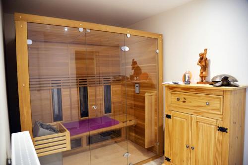 a glass shower in a room with a wooden cabinet at Au logis de Bayard in Vareilles