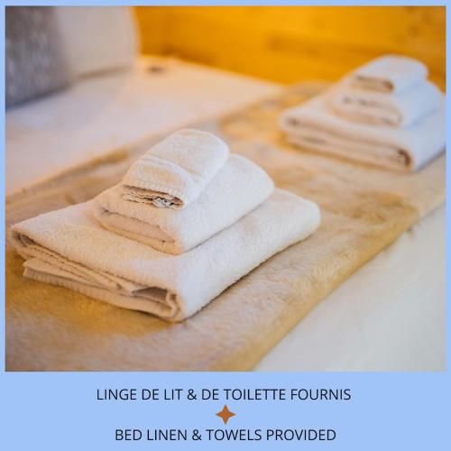 three towels are sitting on a wooden cutting board at Sibiti, charmant 2 pièces à 20 minutes de Paris in Le Blanc-Mesnil