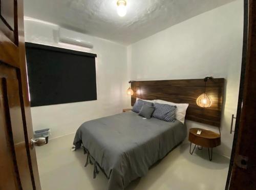 a bedroom with a bed and a large screen at Suite en área turística de Manzanillo con club de playa in Manzanillo