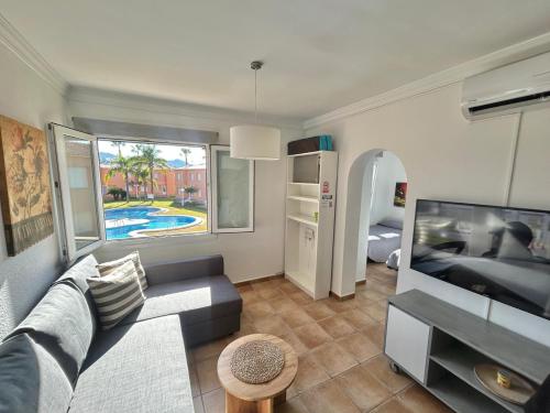 a living room with a couch and a flat screen tv at Apartamentos Ambatà AP-1 Varsovia in Oliva