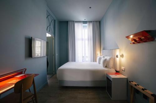 a bedroom with a large white bed and a window at Esqina Cosmopolitan Lodge in Lisbon