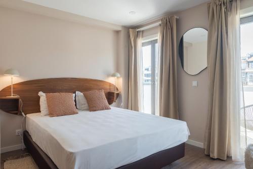 a bedroom with a large bed and a large window at Uma Poveiros in Porto