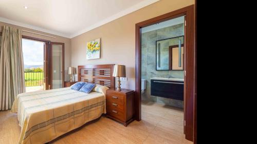 a bedroom with a bed and a bathroom with a tub at Son Monget in Muro