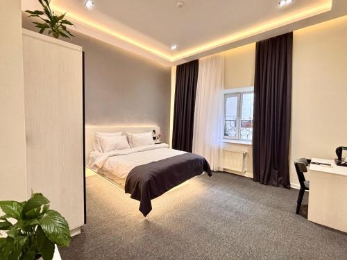 a bedroom with a bed and a desk and a window at JM Central Boutique Hotel in Baku