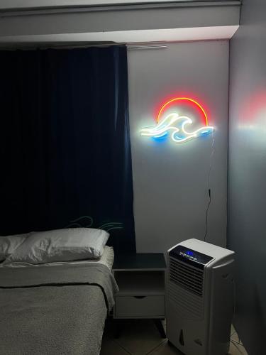 a room with a bed and a neon sign on a wall at Estudio in Zamora de Hidalgo