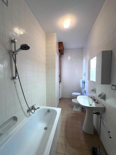 a bathroom with a tub and a sink and two toilets at Hospital - WI-FI 3 Bedrs in Reggio Emilia