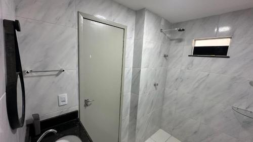 a bathroom with a shower with a toilet and a mirror at Via do Sol flats in Amontada