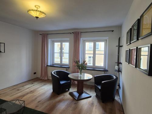 a living room with a table and chairs and windows at FeWo Altstadt in Stralsund