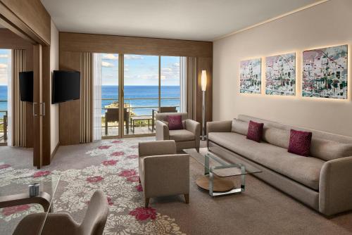 a living room with a couch and chairs and a view of the ocean at Concorde Luxury Resort & Casino in Vokolidha