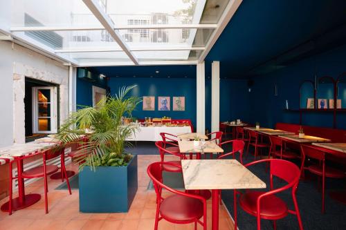 a restaurant with red chairs and tables and blue walls at Esqina Cosmopolitan Lodge in Lisbon
